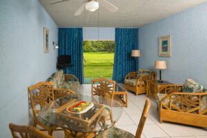 Bright and spacious living room at Plum Tree Club apartment in Barbados, featuring comfortable seating, dining area, and views of the garden.