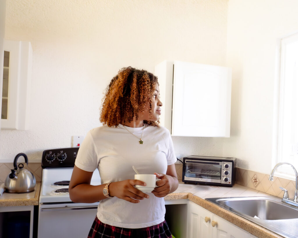 Guest making coffee in the full kitchen of a self-catering apartment at Plum Tree Club Barbados