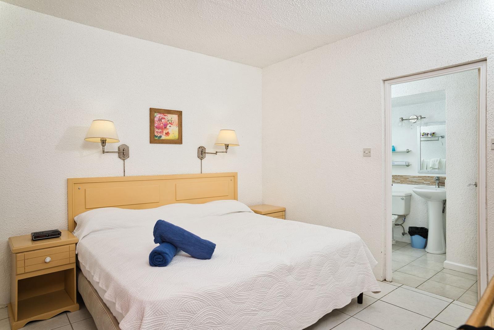 Bedroom at Plum Tree Club with a double bed and an ensuite bathroom through the doorway